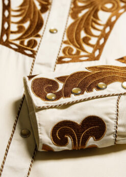 Elegante Westernbluse mit großartiger Stickerei an Brust, Rücken und Manschetten. Die Knopfleiste ist durch eine Kordelpaspelierung abgesetzt. Die Fake Smileys und die fünffach geknöpften Manschetten spiegeln die klassische Westernmode wider.