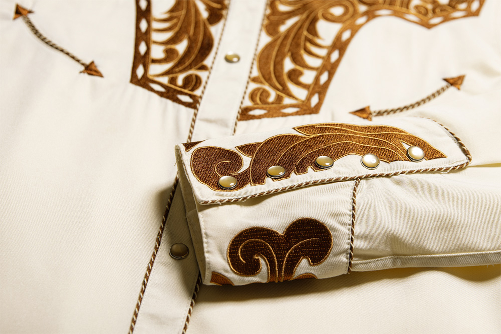 Elegante Westernbluse mit großartiger Stickerei an Brust, Rücken und Manschetten. Die Knopfleiste ist durch eine Kordelpaspelierung abgesetzt. Die Fake Smileys und die fünffach geknöpften Manschetten spiegeln die klassische Westernmode wider.